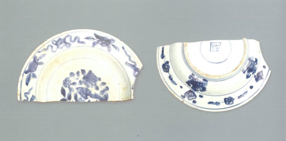 【青花瓷器】青花花鳥折沿盤(殘)
Foliated edge blue-and-white dish with plants and birds (Shard)
萬曆早期(Early Wanli)
口徑(MD)17.4cm，足徑(FD)10.8cm，高(H)2.2cm
胎質緻密細白，釉泛青。青花發色分布不均，有的較鮮豔，藍中微泛紫;有的發色較淡，藍中微泛灰。盤沿有破損。盤心裝飾花草紋，腹留白，沿面繪雜寶紋;外壁腹及沿邊繪花草紋。外底青花單圈內繪青花方形框“福”字款，圈足有窯粘。
