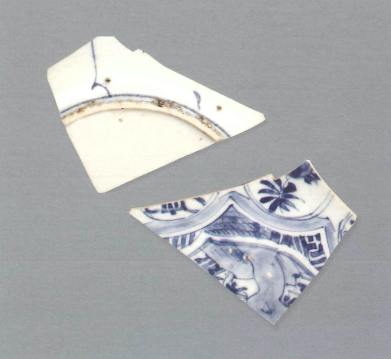 【青花瓷器】圖為澳門出土的山石花卉盤(殘)
Blue-and-white dish with rock and flower design (Shard)
萬曆中期(Middle Wanli)
口徑(MD) 16.2cm
胎薄，細膩緻密。釉青亮，表面有縮釉點。青花發色較淡。該標本盤心為錦地菱形開光，繪山石花卉。內壁裝飾圓形開光，內繪花卉。外壁以豎線分隔。矮圈足，足根有窯粘。
