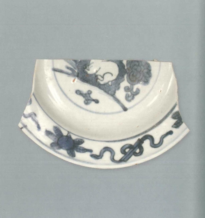 【青花瓷器】澳門出土的青花兔紋折沿盤(殘)
Foliated edge blue-and-white dish with rabbit design (Shard)
萬曆早中期(Early to Middle Wanli)
口徑(MD) 16.8cm， 足徑(FD) 10cm， 高(H) 2.3cm
胎質緻密，釉泛青灰。青花發色較淡，藍中微泛灰。盤心飾兔子纏枝紋，腹留白，盤沿繪有雜寶紋。外盤沿及腹繪有雜草紋，外底底心青花單圈內繪青花方形框“福”字款，圈足有窯粘。
