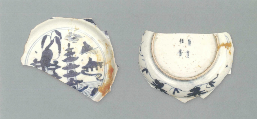 【青花瓷器】澳門出土的青花山水樓閣紋盤(殘)
Blue-and-white dish with pavilion in landscape (Shard)
萬曆早中期(Early to Middle Wanli)
足徑(FD) 8.8cm
胎質緻密發乳白，釉泛青灰。青花發色較淡，藍中微泛灰。盤心飾青花山水樓閣紋，盤沿繪有花卉紋。外盤沿及腹繪有雜草花卉紋，外底底心青花雙圈內繪“富貴佳器”款，圈足有跳刀痕及窯粘。