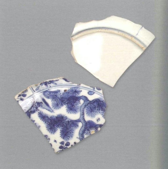 【青花瓷器】澳門出土的山石松樹紋盤(殘)
Blue-and-white dish with pine and rocks (Shard)
萬曆晚期(Late Wanli)
足徑(FD) 16.2cm
器物胎質細膩緻密，釉滋潤。青花發色鮮豔，藍中微泛青紫。盤心青花雙圈內繪山石松樹，內壁開光之間僅用兩根直線相隔，內繪樹木花卉。外壁開光以直線分隔。矮圈足，有少量窯粘。
