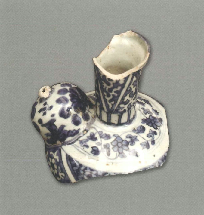 【青花瓷器】澳門出土的青花花卉紋軍持(殘)
Blue-and-white kendi with. flower design (Shard)
萬曆中期(Middle Wanli)
高(H) 12.8cm
胎質緻密，釉泛青。青花發色較純正，藍中泛紫。上半部分保留得相對較完整，為圓乳形流，直頸。頸部的裝飾以三角形做分割，紋樣幾乎佈滿整個瓶身，圓乳形流和肩部為纏枝花卉紋，器身可見錦地紋。青花以藍地白花和白地藍花兩種方式進行裝飾，混水塗抹。
