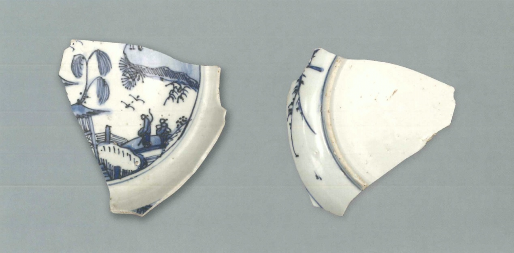 【青花瓷器】青花山水人物圖盤(殘)
Blue-and-white dish with figures in landscape (Shard)
足径(FD) 12.1cm
胎質緻密發乳白，釉泛青灰。青花發色較淡，藍中微泛灰。盤心飾庭院山水人物紋，類似古代傅統繪畫中的“文士賞遊”圖，腹留白。外盤沿及腹繪有竹葉紋，圈足有跳刀痕及窯粘。