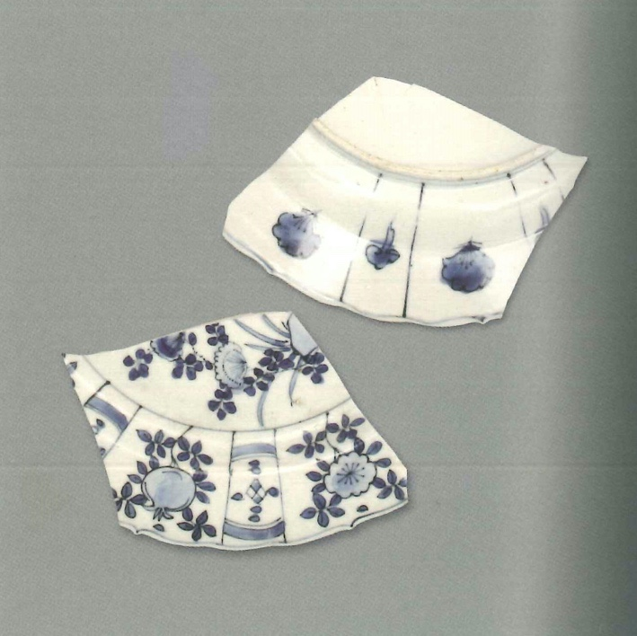 【青花瓷器】草堆街出土的青花花卉紋折沿盤(殘)
Foliated edge blue-and-white dish with flower design (Shard) 
胎質緻密發乳白，釉泛青灰。青花發色較淡，藍中微泛灰。此為折沿青花小盤，裝飾紋樣佈滿整個盤心、腹及沿面。內壁大開光內繪梅花、石榴等吉祥花果，中間的小開光內上下兩根弧線，裏面是菱形方格紋與圓點組成的十字形圖案。外壁大開光的大小分格與內壁一致，大開光內是一朵花朵，小開光內是一拖腳的如意形雲頭，均是青花先勾出簡單輪廓，再混水塗抹。
萬曆晚期(Late Wanli)
口徑(MD) 20.3cm，足徑(FD) 12.2cm，高(H) 2